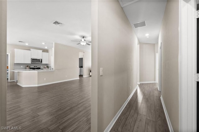 hallway with dark hardwood / wood-style flooring