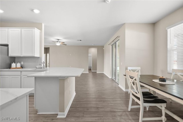 kitchen featuring ceiling fan, sink, white cabinets, and dark hardwood / wood-style floors