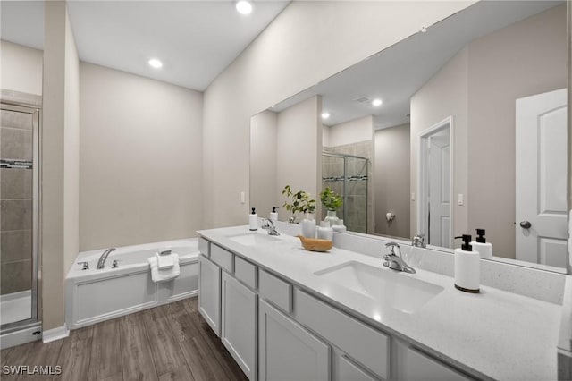 bathroom featuring hardwood / wood-style flooring, vanity, and separate shower and tub