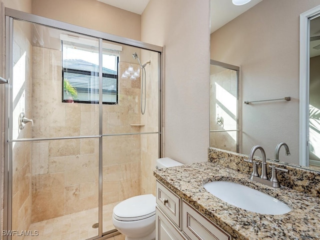 bathroom featuring an enclosed shower, vanity, and toilet