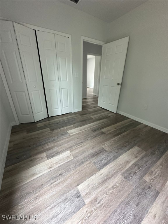 942 Sunrise Blvd, Lehigh Acres, FL 33974 - unfurnished bedroom with a closet and wood finished floors