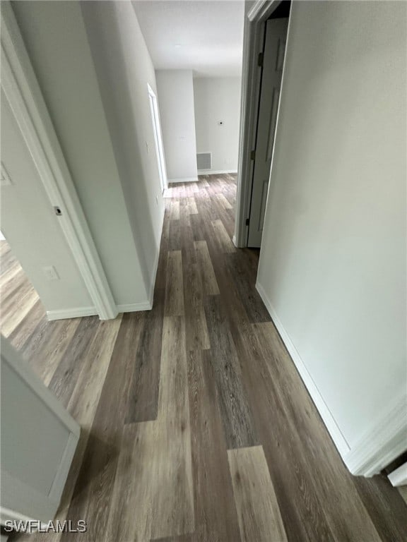 942 Sunrise Blvd, Lehigh Acres, FL 33974 - hallway with dark wood-style floors and baseboards