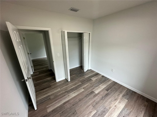 942 Sunrise Blvd, Lehigh Acres, FL 33974 - unfurnished bedroom featuring dark wood-style floors and a closet
