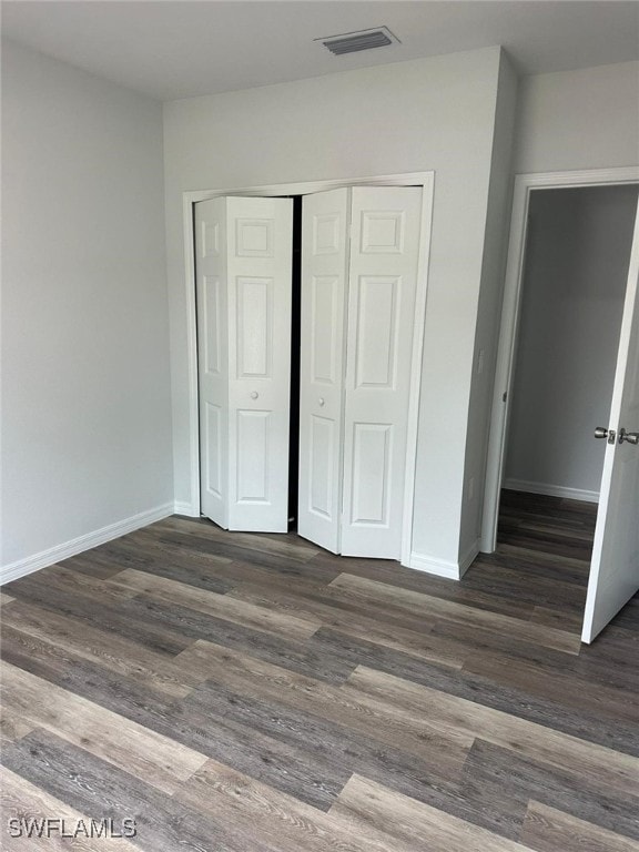 942 Sunrise Blvd, Lehigh Acres, FL 33974 - unfurnished bedroom featuring a closet and wood finished floors