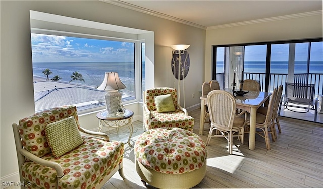 sitting room with ornamental molding, light hardwood / wood-style floors, and a water view