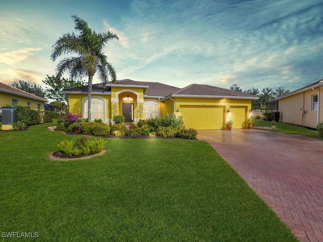 view of front of home featuring a garage, central AC, and a lawn