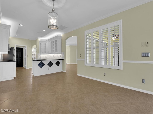 unfurnished living room with ornamental molding, a notable chandelier, light tile patterned flooring, and sink