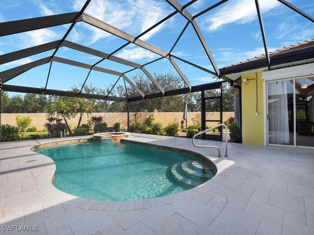 view of pool featuring a patio, glass enclosure, and an in ground hot tub