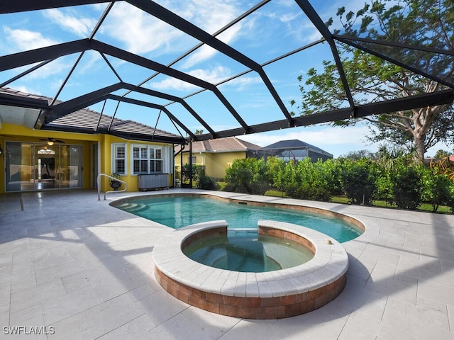 view of swimming pool with an in ground hot tub, a lanai, and a patio area