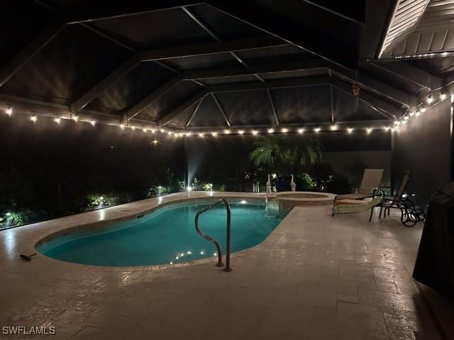 pool at twilight featuring an in ground hot tub, glass enclosure, and a patio area