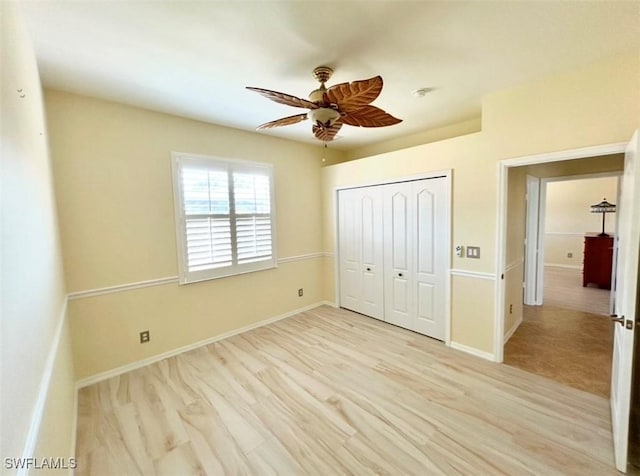 unfurnished bedroom featuring ceiling fan, a closet, and light wood-type flooring