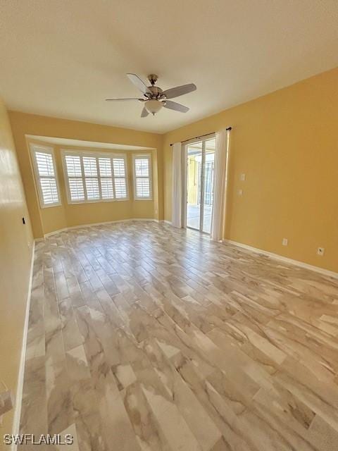 spare room with a healthy amount of sunlight, ceiling fan, and light wood-type flooring