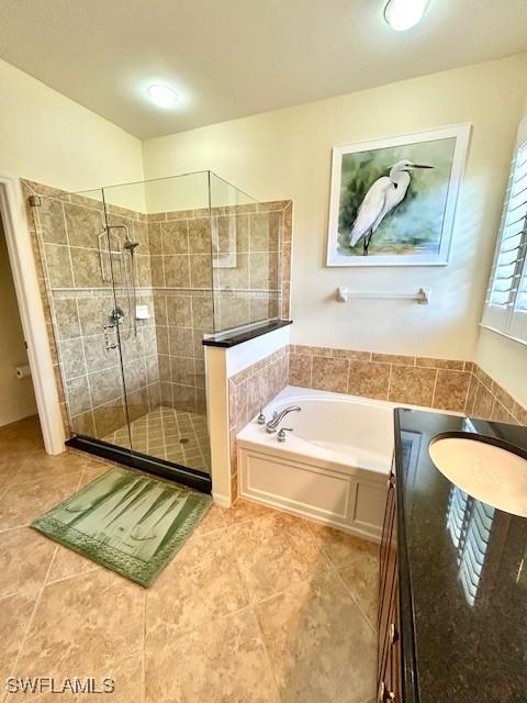 bathroom featuring tile patterned floors, plus walk in shower, and sink