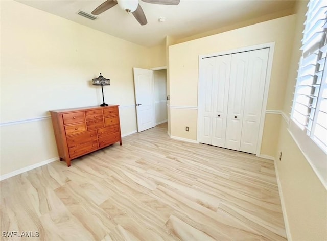 bedroom with ceiling fan, light hardwood / wood-style floors, and a closet