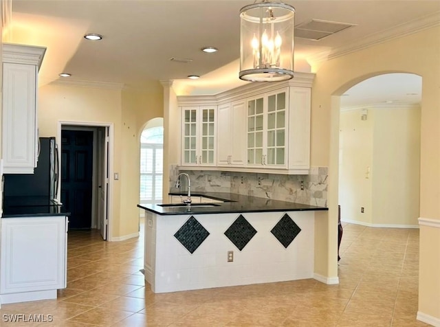 kitchen with pendant lighting, white cabinetry, sink, kitchen peninsula, and crown molding