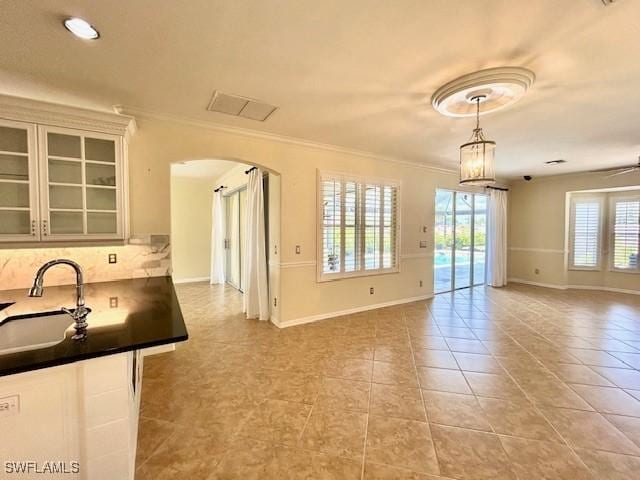 kitchen featuring crown molding, sink, light tile patterned floors, and white cabinets