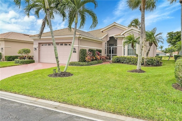 mediterranean / spanish home with a garage and a front lawn