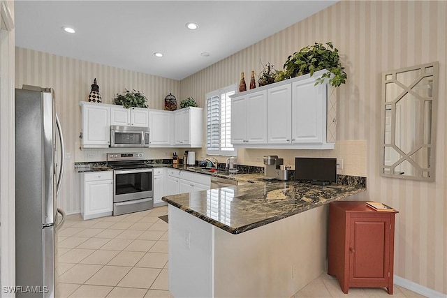 9209 Garden Pointe, Fort Myers, FL 33908 - kitchen with stainless steel appliances, kitchen peninsula, light tile patterned floors, and white cabinets