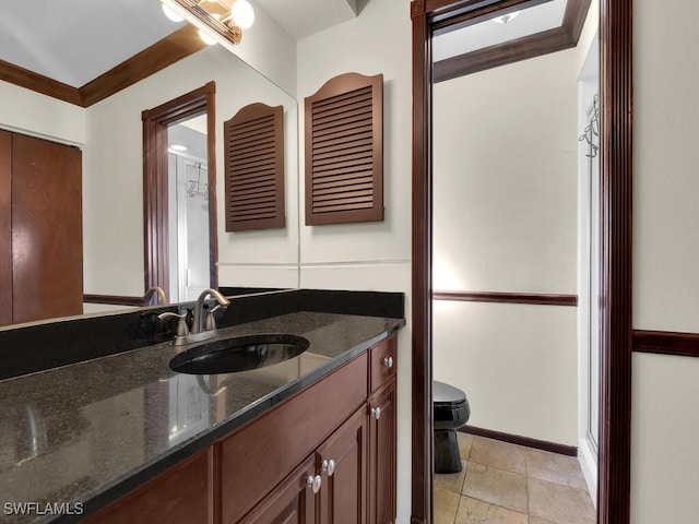 bathroom with tile patterned floors, vanity, toilet, and ornamental molding