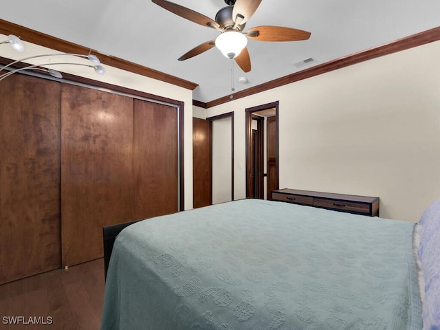 bedroom with ceiling fan, ornamental molding, and dark wood-type flooring