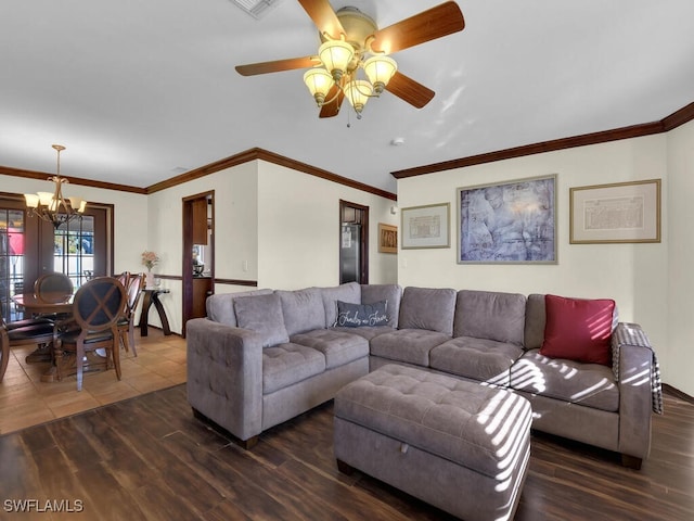 living room featuring ornamental molding, ceiling fan with notable chandelier, and dark wood-type flooring