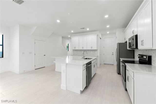 kitchen featuring white cabinetry, sink, a center island with sink, and appliances with stainless steel finishes