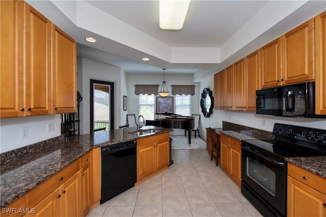 kitchen with dark stone counters, pendant lighting, black appliances, and sink