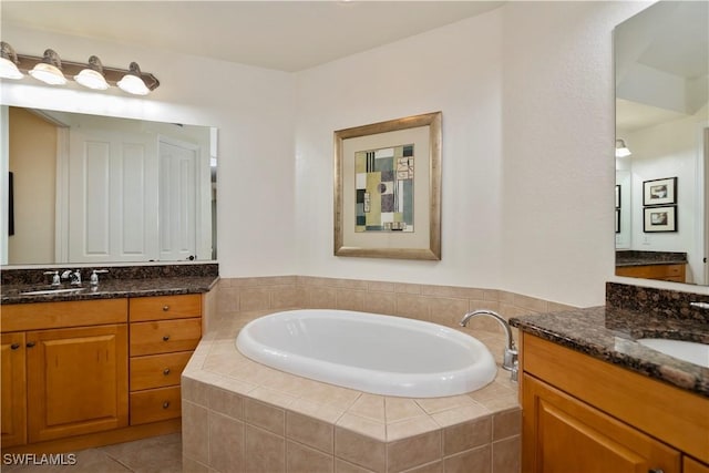 bathroom featuring tiled tub, tile patterned flooring, and vanity