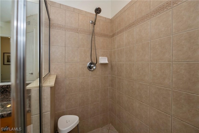 bathroom with vanity and a tile shower