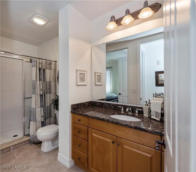 bathroom with toilet, a shower with curtain, vanity, and tile patterned floors