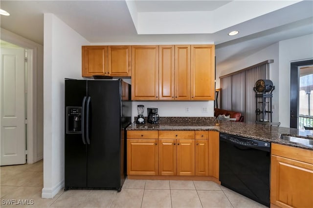 kitchen featuring black appliances, light tile patterned flooring, dark stone countertops, and sink