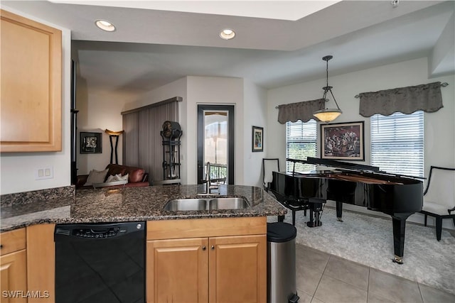 kitchen featuring dark stone counters, sink, light tile patterned floors, black dishwasher, and hanging light fixtures