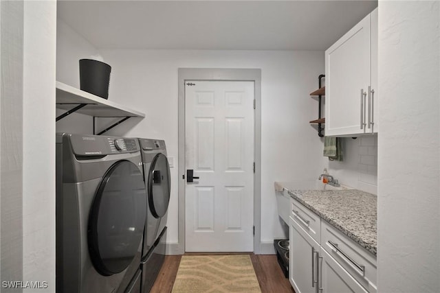 washroom with cabinets, dark wood-type flooring, and independent washer and dryer