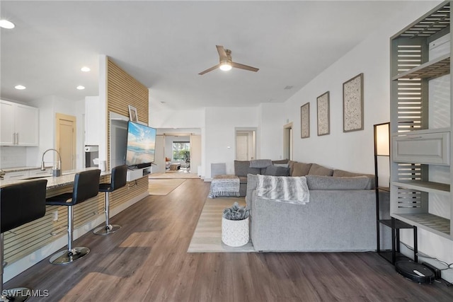 living room featuring ceiling fan and dark hardwood / wood-style flooring