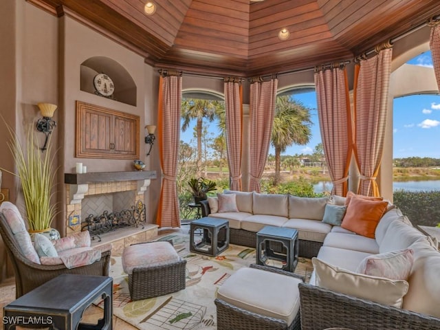 interior space with an outdoor living space with a fireplace, a gazebo, and a water view