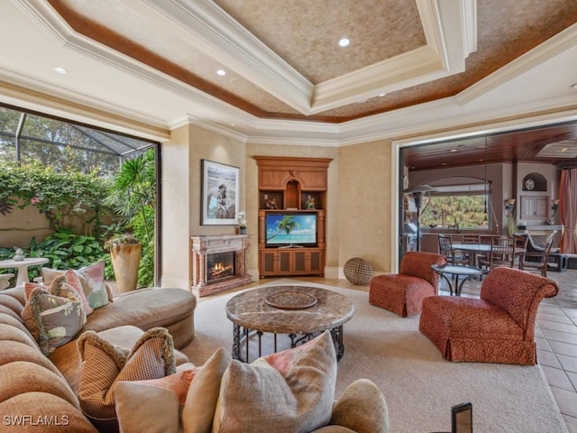 living room with a raised ceiling, plenty of natural light, ornamental molding, and light tile patterned flooring