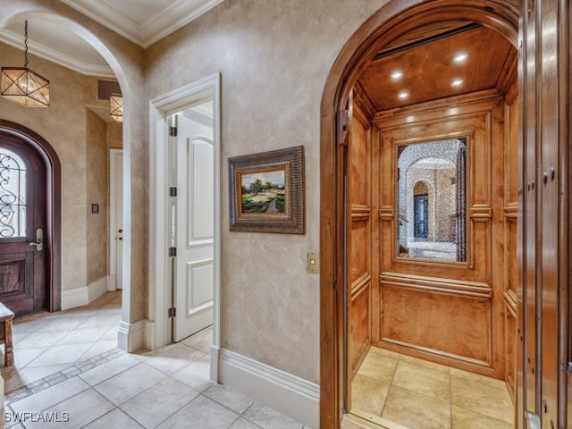 tiled entrance foyer featuring crown molding