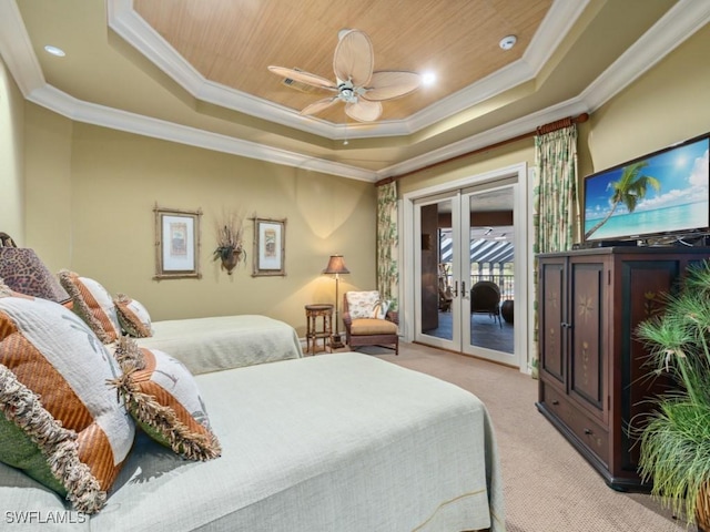 carpeted bedroom featuring access to outside, french doors, ceiling fan, ornamental molding, and a tray ceiling