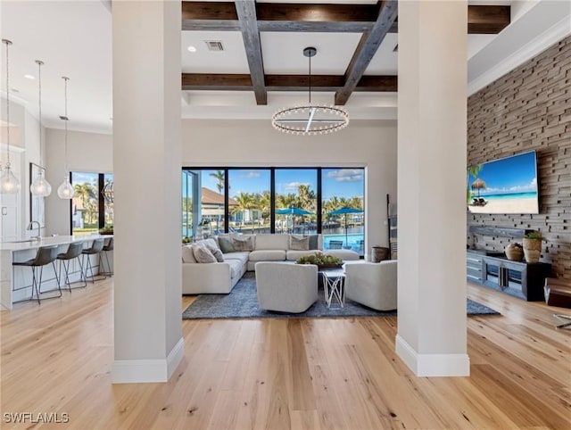 living room featuring coffered ceiling, a healthy amount of sunlight, light hardwood / wood-style flooring, and beam ceiling