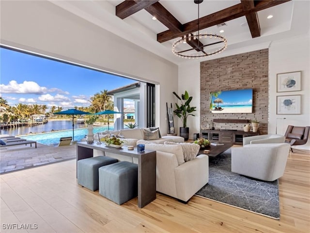 living room with coffered ceiling, light hardwood / wood-style flooring, beamed ceiling, and a water view