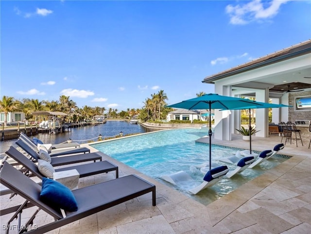 view of pool featuring a patio area, ceiling fan, and a water view