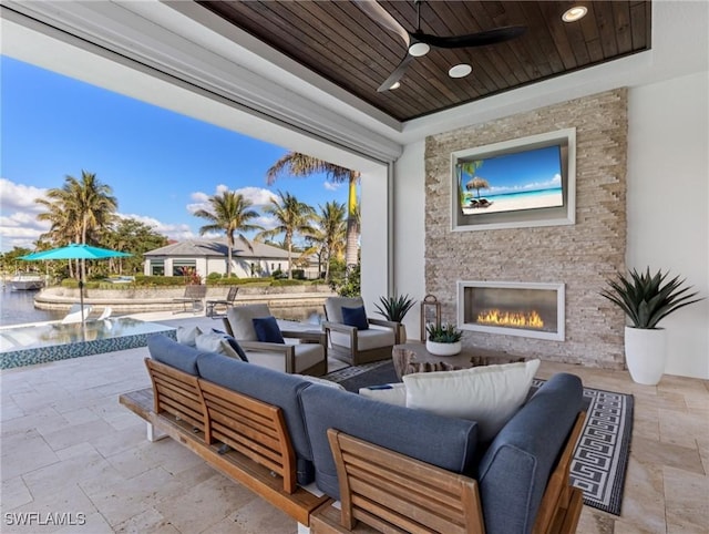 view of patio / terrace with ceiling fan and an outdoor living space with a fireplace