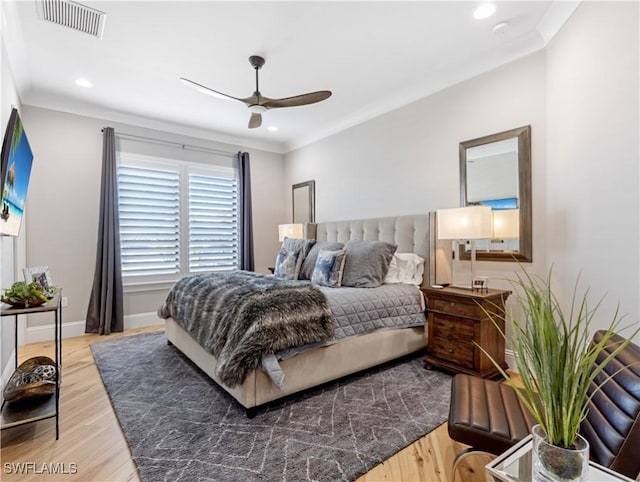 bedroom with ornamental molding, ceiling fan, and hardwood / wood-style floors