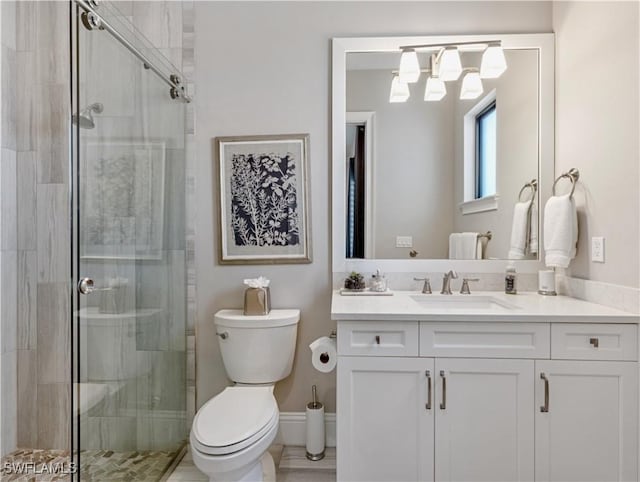 bathroom featuring toilet, an enclosed shower, and vanity