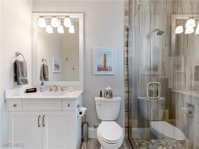 bathroom with an enclosed shower, vanity, and toilet