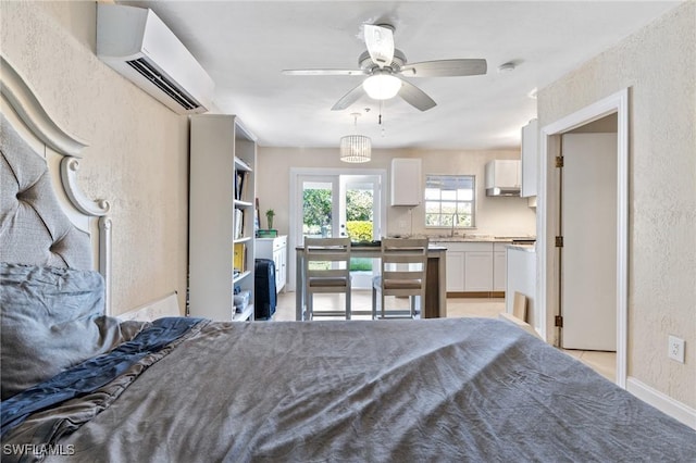 bedroom featuring ceiling fan, an AC wall unit, and sink