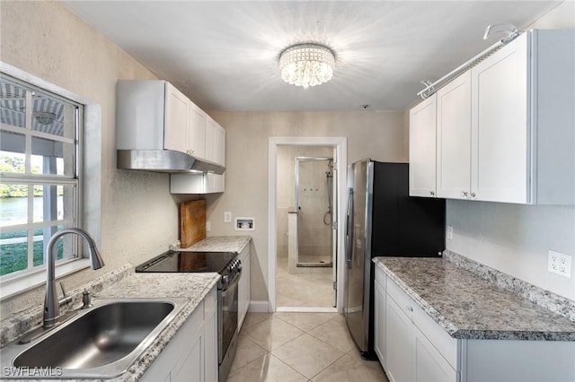 kitchen featuring electric range oven, white cabinets, sink, a chandelier, and light tile patterned flooring