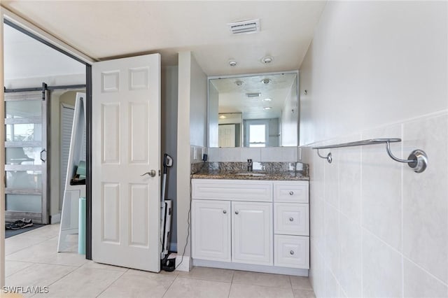 bathroom with tile patterned flooring, vanity, and tile walls