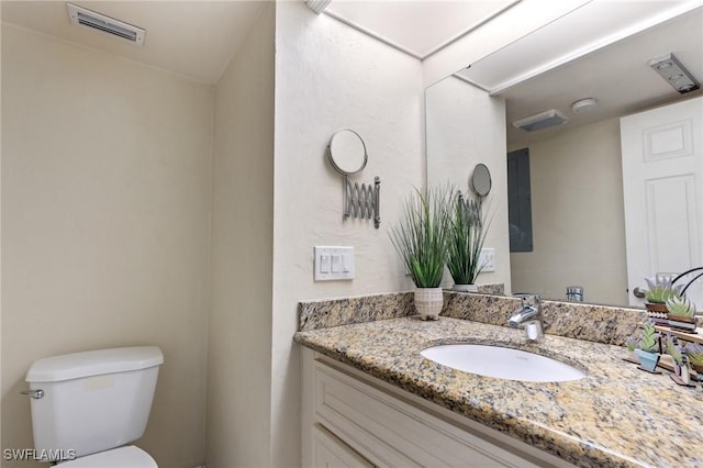 bathroom featuring toilet and vanity