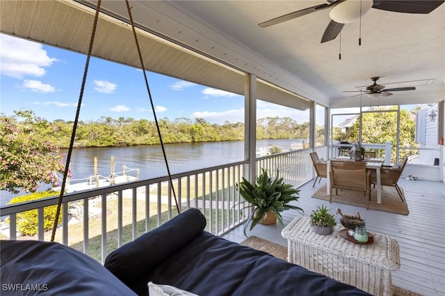 sunroom featuring a water view and ceiling fan